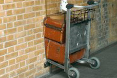 Andén de la estación de King's Cross de Londres que muestra un carrito de equipaje que desaparece en una pared ladrillo bajo el cartel “Andén 9 ¾”.