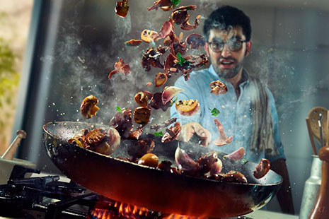 Las mejores fotos del año cocina cocinero moviendo una sartén con comida sobre los fogones