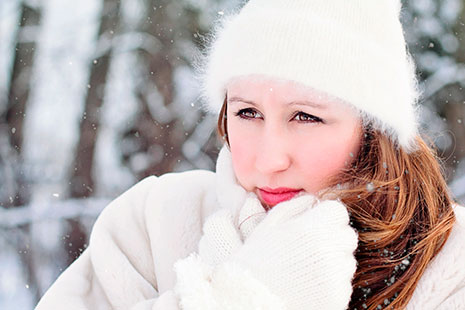 Mejores remedios naturales contra el frío abrigarse Mujer con gorro y guantes blancos