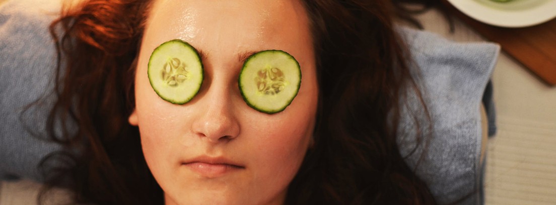 mascarillas faciales caseras efectivas pepino en los ojos Cara de mujer con rodajas de pepino sobre los ojos