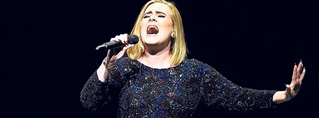 La cantante Adele con vestido azul y micrófono