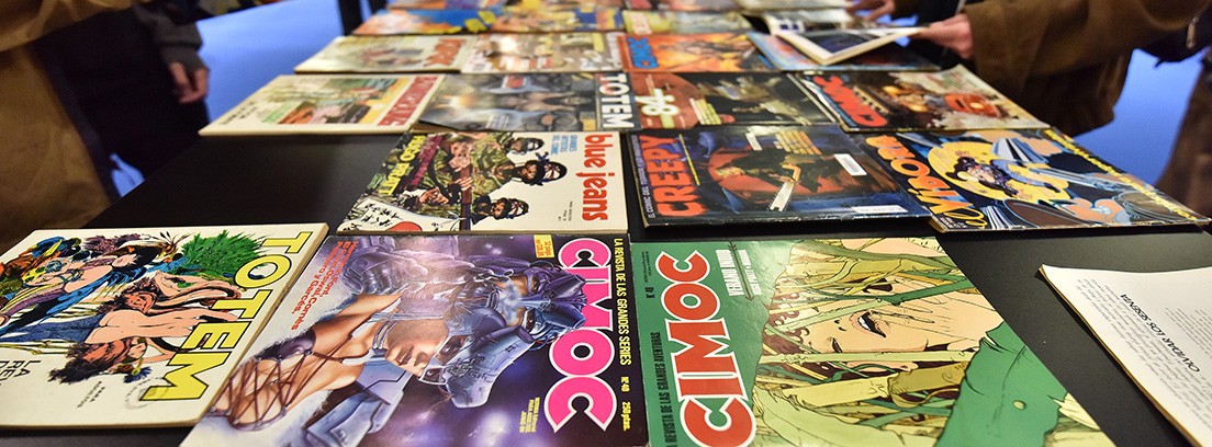 Salón del Cómic Barcelona 2018 cosplay Tres personas disfrazadas miran una revista que sujeta una de ellas