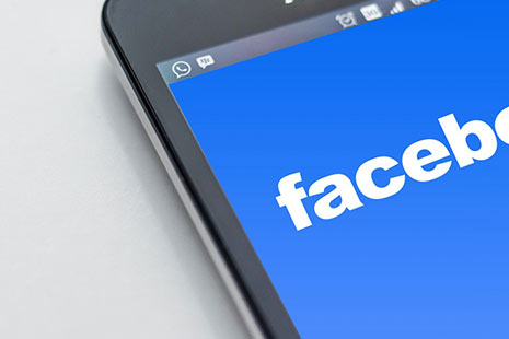 Cómo recuperar fotos de Facebook Pantalla de móvil con la página de inicio de Facebook