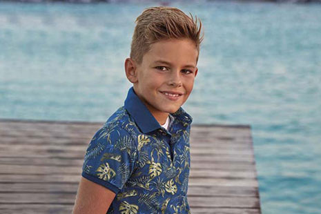 Niño con camisa de hojas de monsteira de Mayoral sentado en un muelle