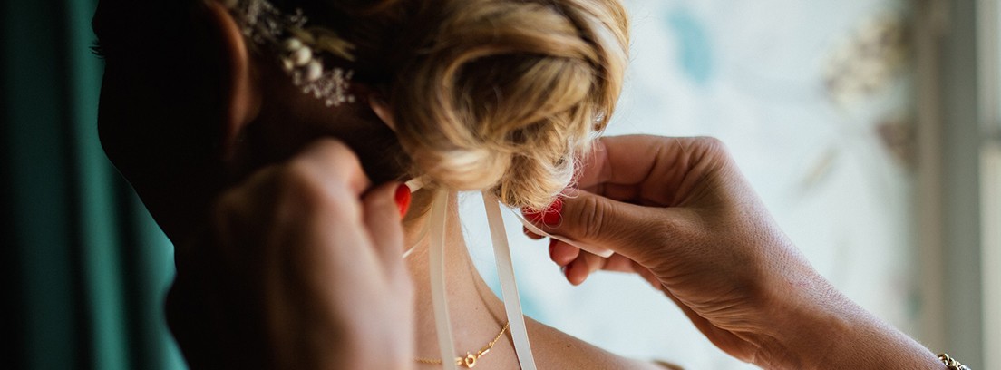 Los mejores peinados para invitadas de boda Peluquera realizando el peinado a una invitada a una boda