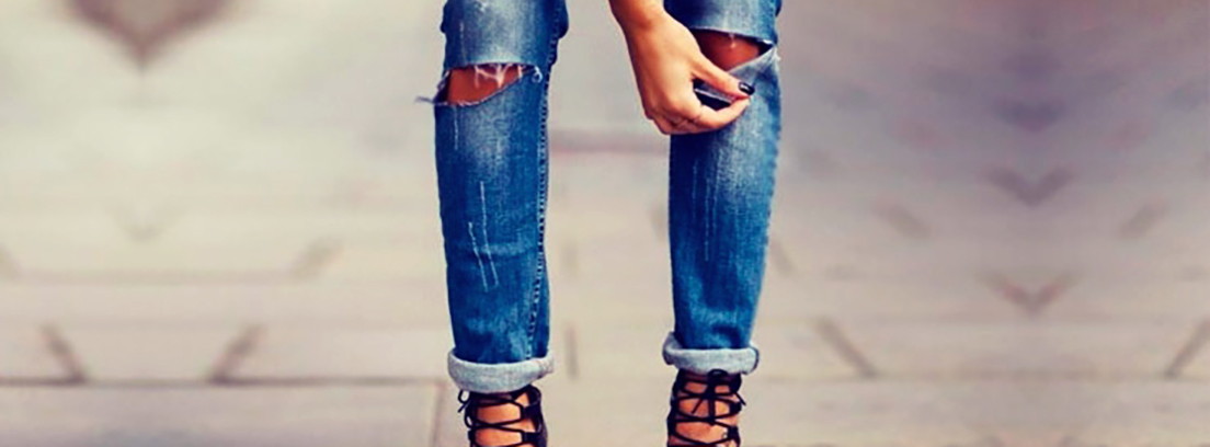 Vuelve la moda de los años 80 vaqueros rotos Chico sentado con pantalones vaqueros rotos y cazadora vaquera