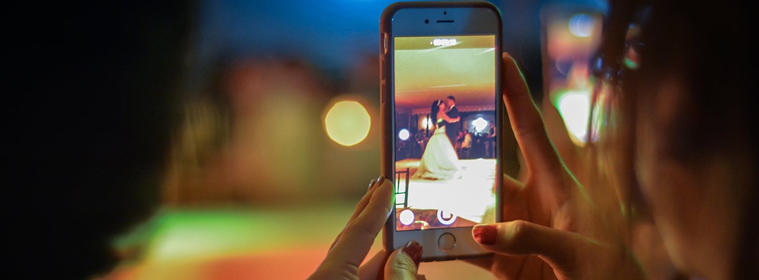 Persona sujeta teléfono móvil con imagen de una pareja de novios bailando