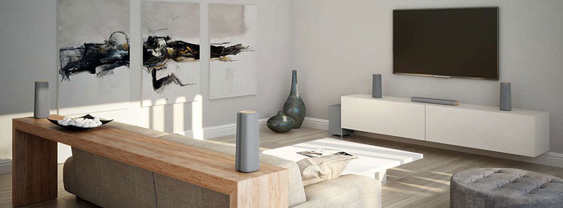 Televisor sobre mueble negro con varios altavoces