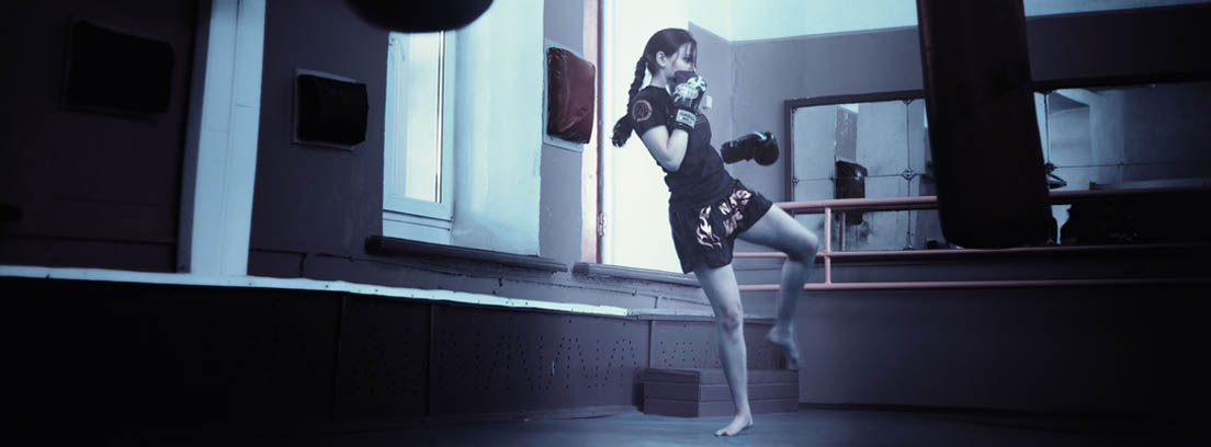 Mujer practicando un deporte de defensa personal con un saco de boxeo