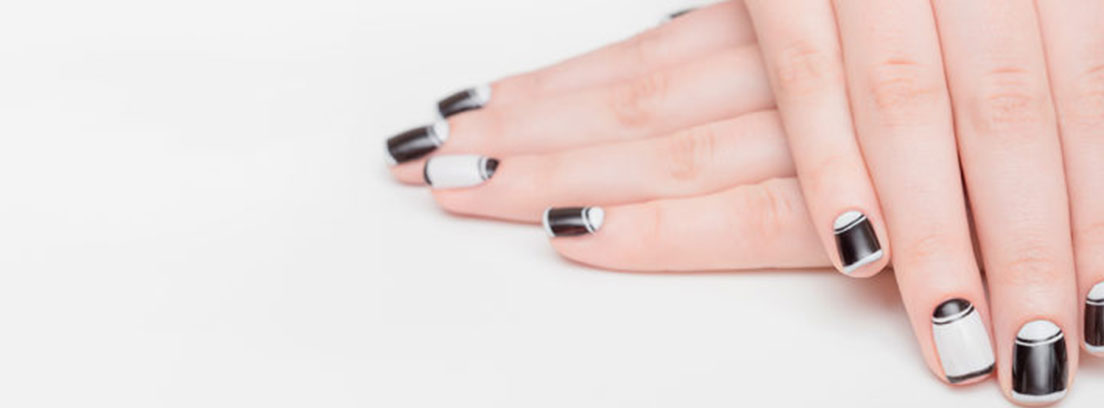 Manos con las uñas pintadas de negro y blanco