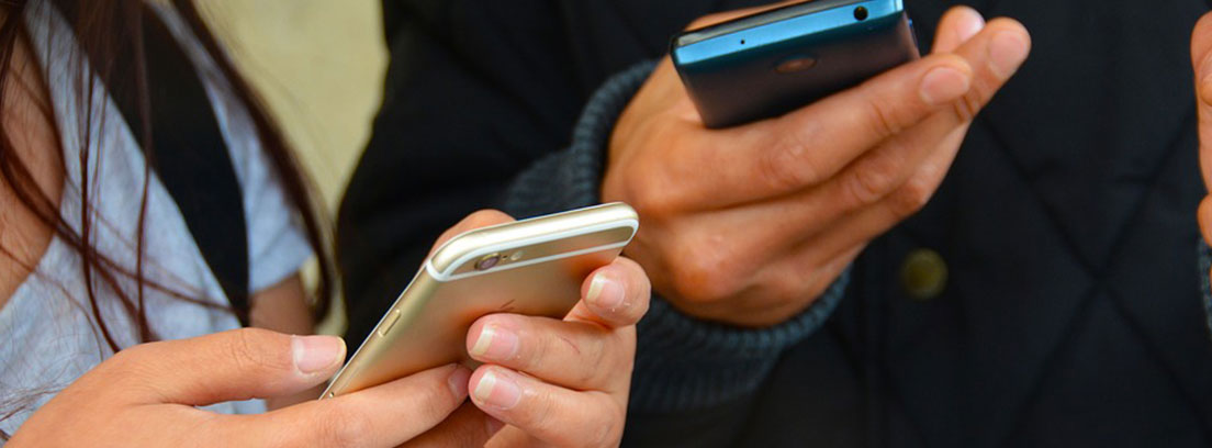 Hombre y mujer compartiendo datos de un móvil a otro