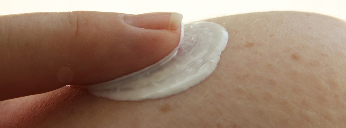 La crema hidratante es uno de los cuidados de depilación más eficientes Mujer aplicándose crema hidratante como cuidados de depilación