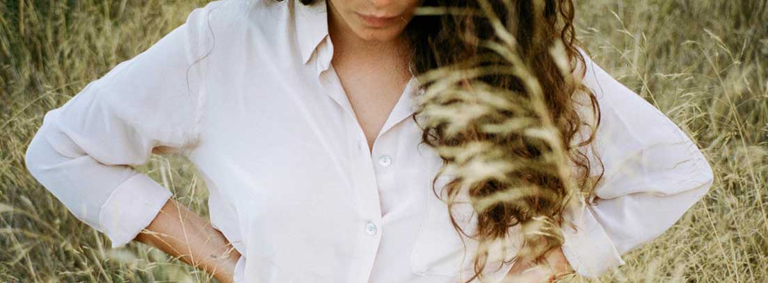 Camisa blanca, otro básico del armario Mujer con camisa blanca y las manos en las caderas