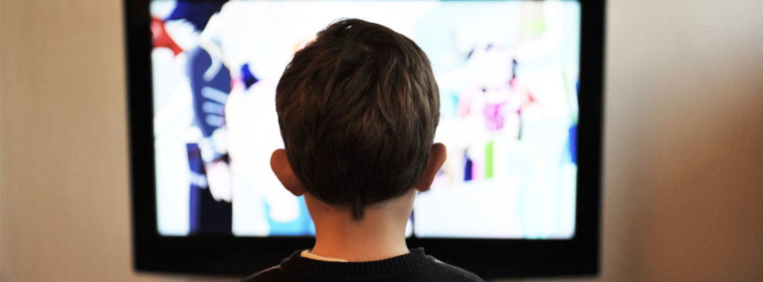 Cómo ver canales de televisión online gratis en España Niño de espaldas frete a una pantalla viendo canales de televisión online gratis en España