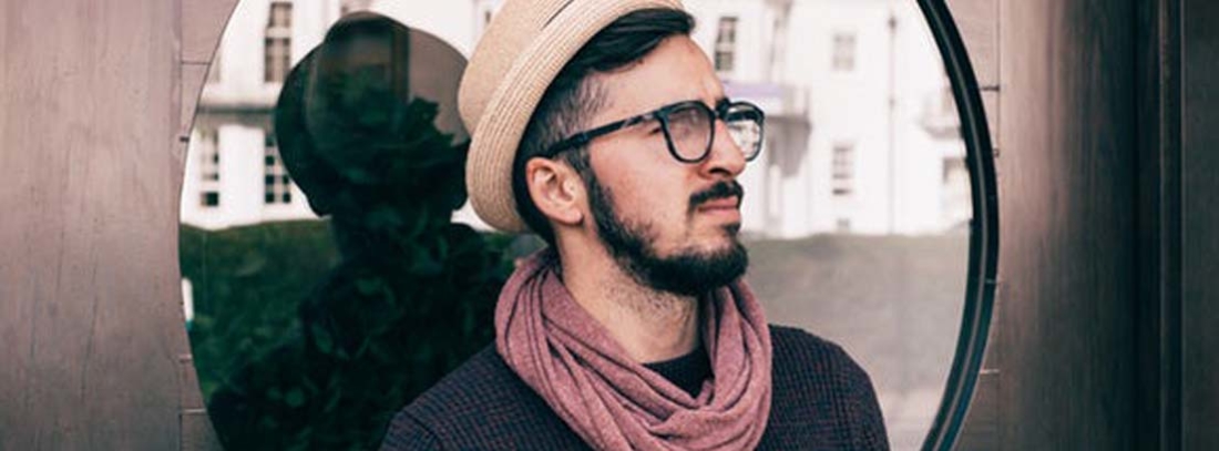 Hombre con gorro, gafas negras y bufanda enroscada en su cuello