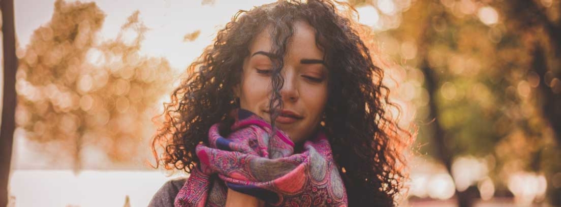 Mujer colocándose una bufanda al cuello