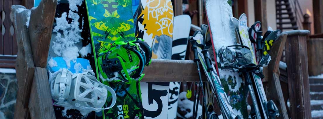 Persona saltando en una pendiente nevada sobre una tabla de snowboard