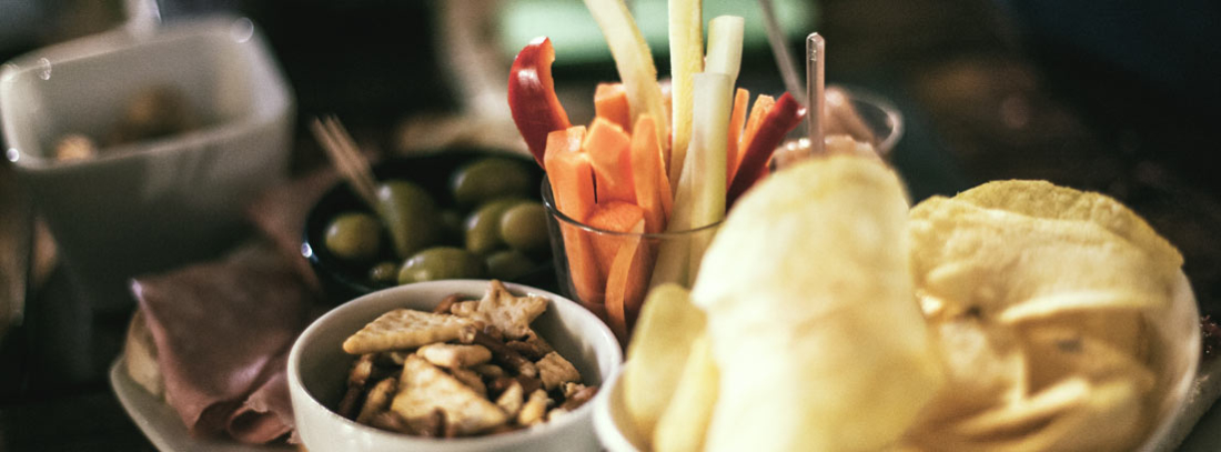 De tapas por Madrid - generacionYOUNG Varias personas sentadas en barriles habilitados como mesas tomando una bebida con tapa en un bar