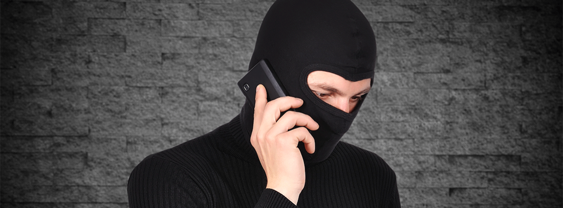 Timos por teléfono - generacionYOUNG ladrón vestido de negro hablando por teléfono