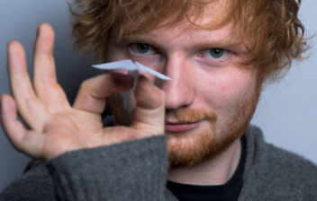 Ed Sheeran sujetando un avión de papel