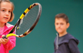 Dos niños jugando al tenis