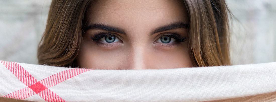 Parte superior de rostro de mujer con parte inferior oculta tras una tela