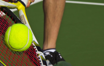 Raqueta de tenia golpeando pelota en una pista