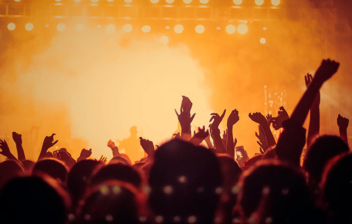 Personas con las manos en alto en un concierto de música