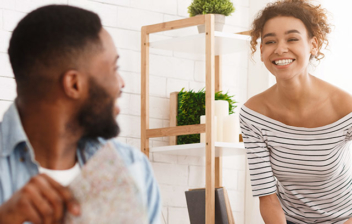 Hombre despliega mapa y mira a mujer que hace maleta