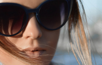Mujer con gafas de sol grandes de pasta negra y forma cat eye.